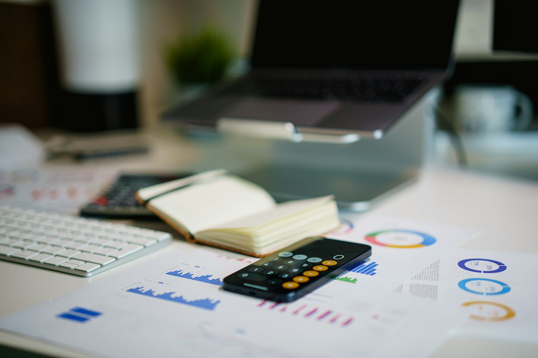 Desk with a calculator, phone and financial charts